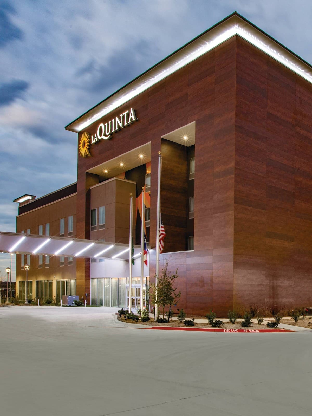 The hotel and its lit monument sign from the front drive